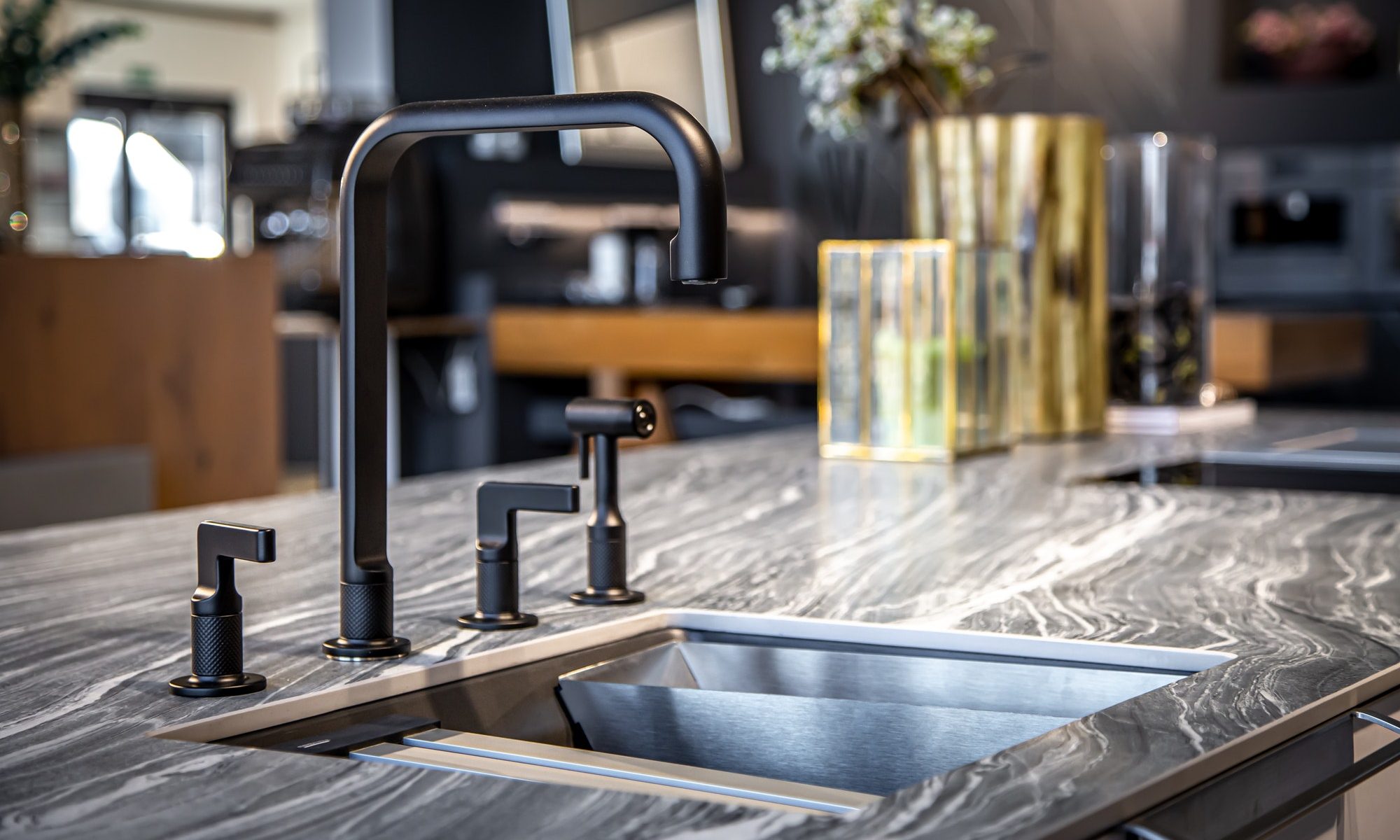 Black faucet with a steel sink in a stylish modern kitchen.
