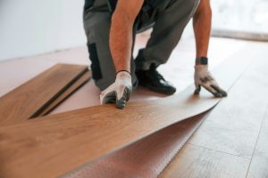 Close up view. Man is installing new laminated wooden floor